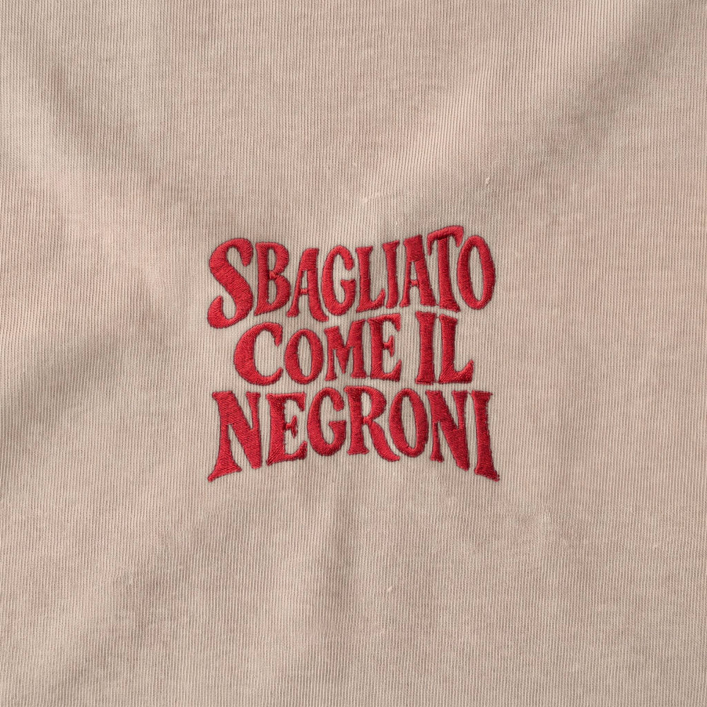 Dettaglio ricamo rosso Sbagliato come il Negroni su beige