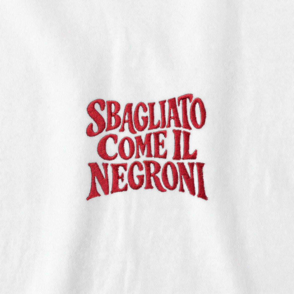 Dettaglio ricamo rosso Sbagliato come il Negroni su bianco